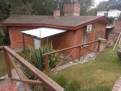 a small house with a fence in front of it at Cabañas Aromas Serranos in Alta Gracia