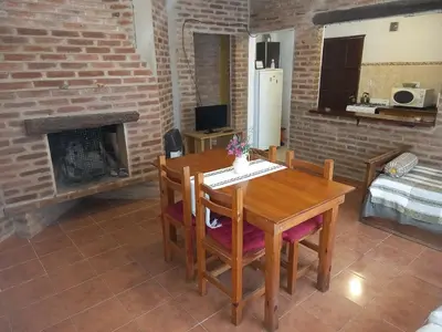 a dining room with a table and a fireplace at Cabañas Aromas Serranos in Alta Gracia