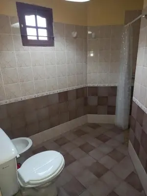 a bathroom with a toilet and a window at Cabañas Aromas Serranos in Alta Gracia