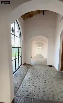an empty hallway with white walls and windows at La Caballeriza Hostel in Tanti Nuevo