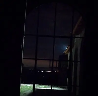 a window at night with a view of the ocean at La Caballeriza Hostel in Tanti Nuevo