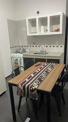 a kitchen with a wooden table with a blanket on it at Departamento VILLA CARLOS PAZ 3P in Villa Carlos Paz
