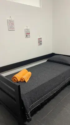 a bed with an orange towel on it in a room at Departamento VILLA CARLOS PAZ 3P in Villa Carlos Paz