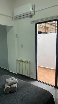 a room with a bed and a large sliding glass door at Departamento VILLA CARLOS PAZ 3P in Villa Carlos Paz