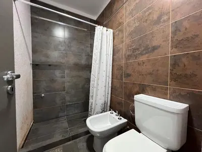a bathroom with a toilet and a shower at Edificio Stefano III - Departamento con cochera y amenities a pocas cuadras del centro in Villa Carlos Paz