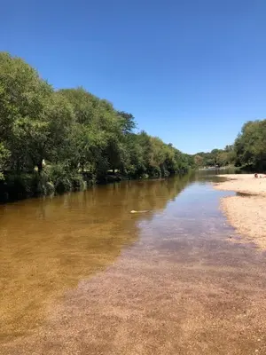 a river with trees on the shore of a beach at Casa L in Los Reartes