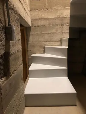 a white staircase in a building with a brick wall at Casa L in Los Reartes