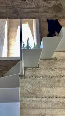 a reflection of a person walking down some stairs at Casa L in Los Reartes