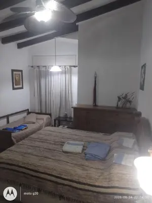 a bedroom with a large bed and a couch at Irupé in Villa Carlos Paz