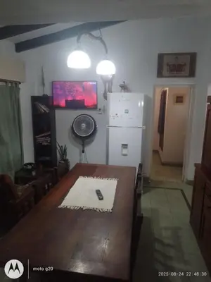 a dining room with a table and a refrigerator at Irupé in Villa Carlos Paz