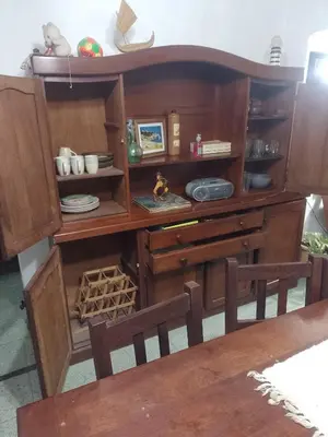 a wooden cabinet with two chairs in a room at Irupé in Villa Carlos Paz