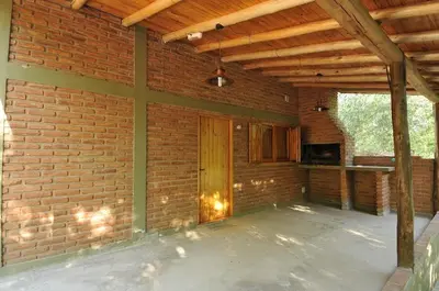 an empty patio with a brick wall and a wooden ceiling at Bosque Encantado Cabañas in Villa Icho Cruz