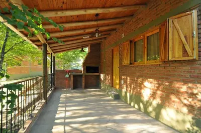 a porch of a brick house with a wooden roof at Bosque Encantado Cabañas in Villa Icho Cruz