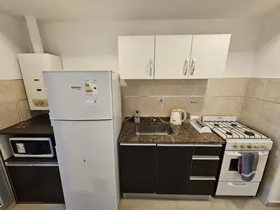 a kitchen with a white refrigerator and a sink at Hermoso y comodo departamento Hospital Cardiologico Kempes Centro de Conveciones Cordoba in Cordoba