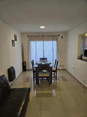 a dining room with a table and chairs and a couch at Hermoso y comodo departamento Hospital Cardiologico Kempes Centro de Conveciones Cordoba in Cordoba
