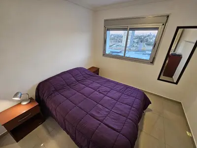a bedroom with a purple bed and a window at Hermoso y comodo departamento Hospital Cardiologico Kempes Centro de Conveciones Cordoba in Cordoba
