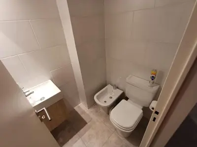 a small bathroom with a toilet and a sink at SERIETÁ 2 dormitorios con pileta y terraza panoramica in Cordoba