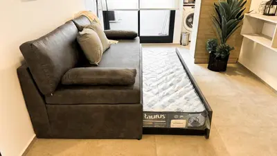 a black couch sitting in a living room at SERIETÁ 2 dormitorios con pileta y terraza panoramica in Cordoba