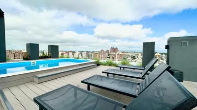 a patio with two tables and a swimming pool on a building at SERIETÁ 2 dormitorios con pileta y terraza panoramica in Cordoba