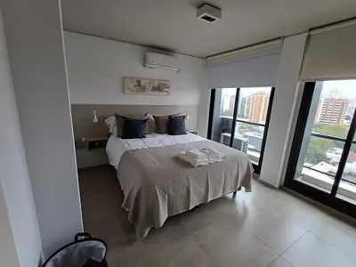 a bedroom with a large bed with blue pillows at SERIETÁ 2 dormitorios con pileta y terraza panoramica in Cordoba