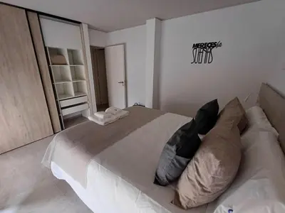 a bedroom with a large white bed with pillows at SERIETÁ 2 dormitorios con pileta y terraza panoramica in Cordoba