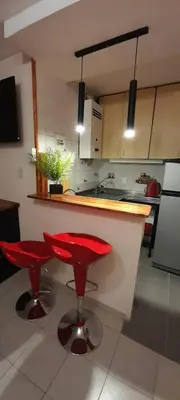 a kitchen with two red stools in a kitchen at Exclusivo Departamento en Nva Cba!!! in Cordoba