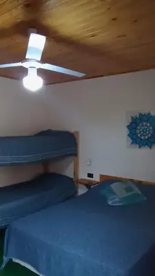a bedroom with a ceiling fan and a blue bed at Complejo Rancho Aparte in Villa Rumipal