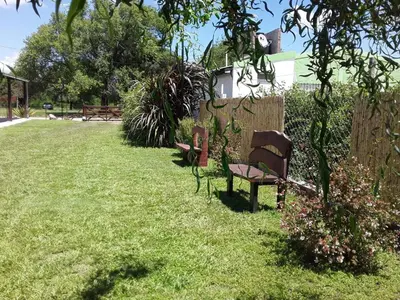 a bench sitting in the grass in a yard at Complejo Rancho Aparte in Villa Rumipal