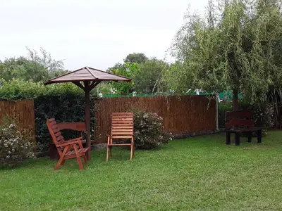two chairs and an umbrella in a yard at Complejo Rancho Aparte in Villa Rumipal