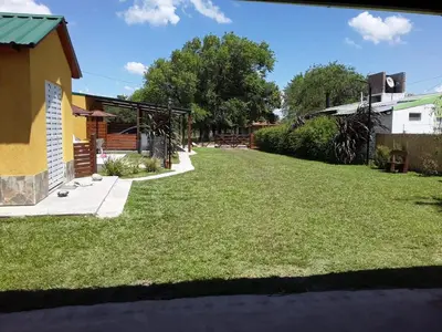 a yard with green grass and a house at Complejo Rancho Aparte in Villa Rumipal