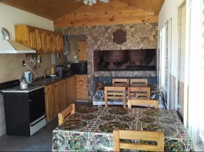 a kitchen with a table with chairs and a stove at Complejo Rancho Aparte in Villa Rumipal
