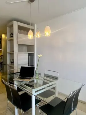 a glass table with a laptop on top of it at Departamento Matilda - B Gral Paz Cba in Cordoba
