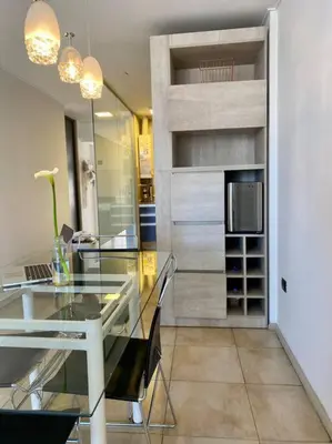 a dining room with a glass table and a refrigerator at Departamento Matilda - B Gral Paz Cba in Cordoba