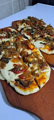 two pizzas on wooden cutting boards on a table at Ayres del Golf Posada-Restó in Merlo