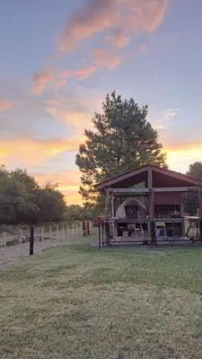 a building with a grill in the middle of a field at Ayres del Golf Posada-Restó in Merlo