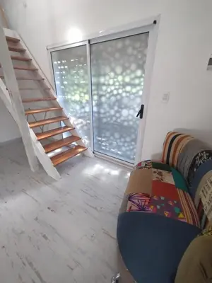 a living room with a couch and a staircase at Schönes Loft VGB in Villa General Belgrano