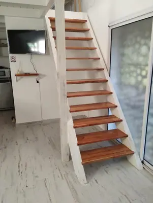 a staircase in a house with wooden treads at Schönes Loft VGB in Villa General Belgrano
