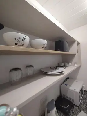 a kitchen shelf with bowls and plates on it at Schönes Loft VGB in Villa General Belgrano