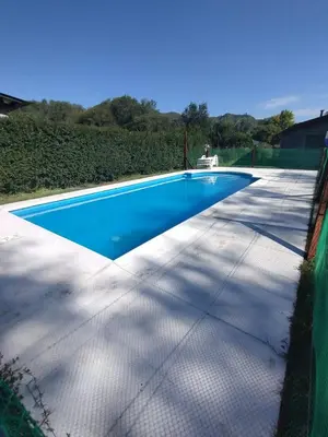 a blue swimming pool with a fence around it at Schönes Loft VGB in Villa General Belgrano