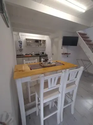 a kitchen with a table and two white chairs at Schönes Loft VGB in Villa General Belgrano