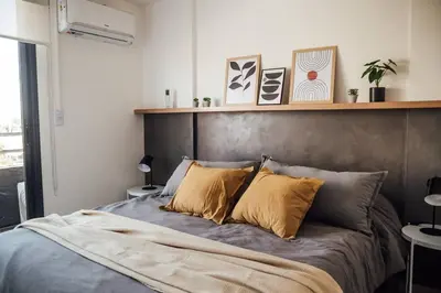 a bedroom with a large bed with a wooden headboard at Tu espacio en la Cuidad in Cordoba