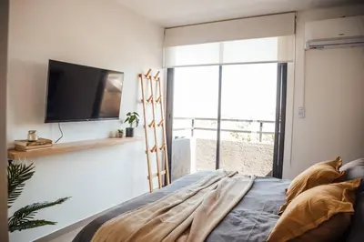 a living room with a tv and a bed and a window at Tu espacio en la Cuidad in Cordoba
