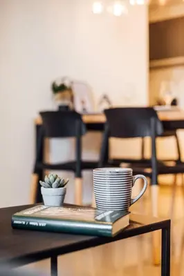 a table with a laptop and a coffee cup on it at Tu espacio en la Cuidad in Cordoba