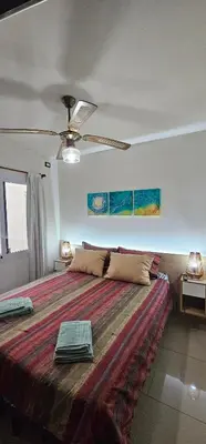 a bedroom with a large bed with a ceiling fan at MIRALEJOS CENTRO op AL in Villa Carlos Paz