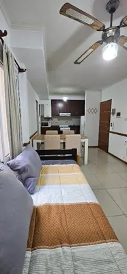 a large bed in a room with a kitchen at MIRALEJOS CENTRO op AL in Villa Carlos Paz