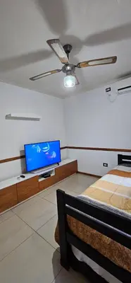 a living room with a tv and a bed at MIRALEJOS CENTRO op AL in Villa Carlos Paz