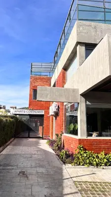 a brick building with a sign on the side of it at Aparts Costalago in Villa Carlos Paz