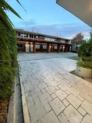 a large building with a brick patio in front of it at Aparts Costalago in Villa Carlos Paz