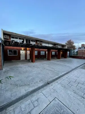 a building with a large parking lot in front of it at Aparts Costalago in Villa Carlos Paz