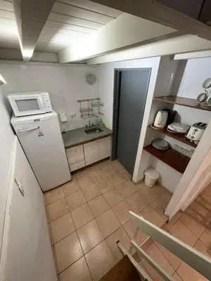 a kitchen with a white refrigerator and a sink at Aparts Costalago in Villa Carlos Paz